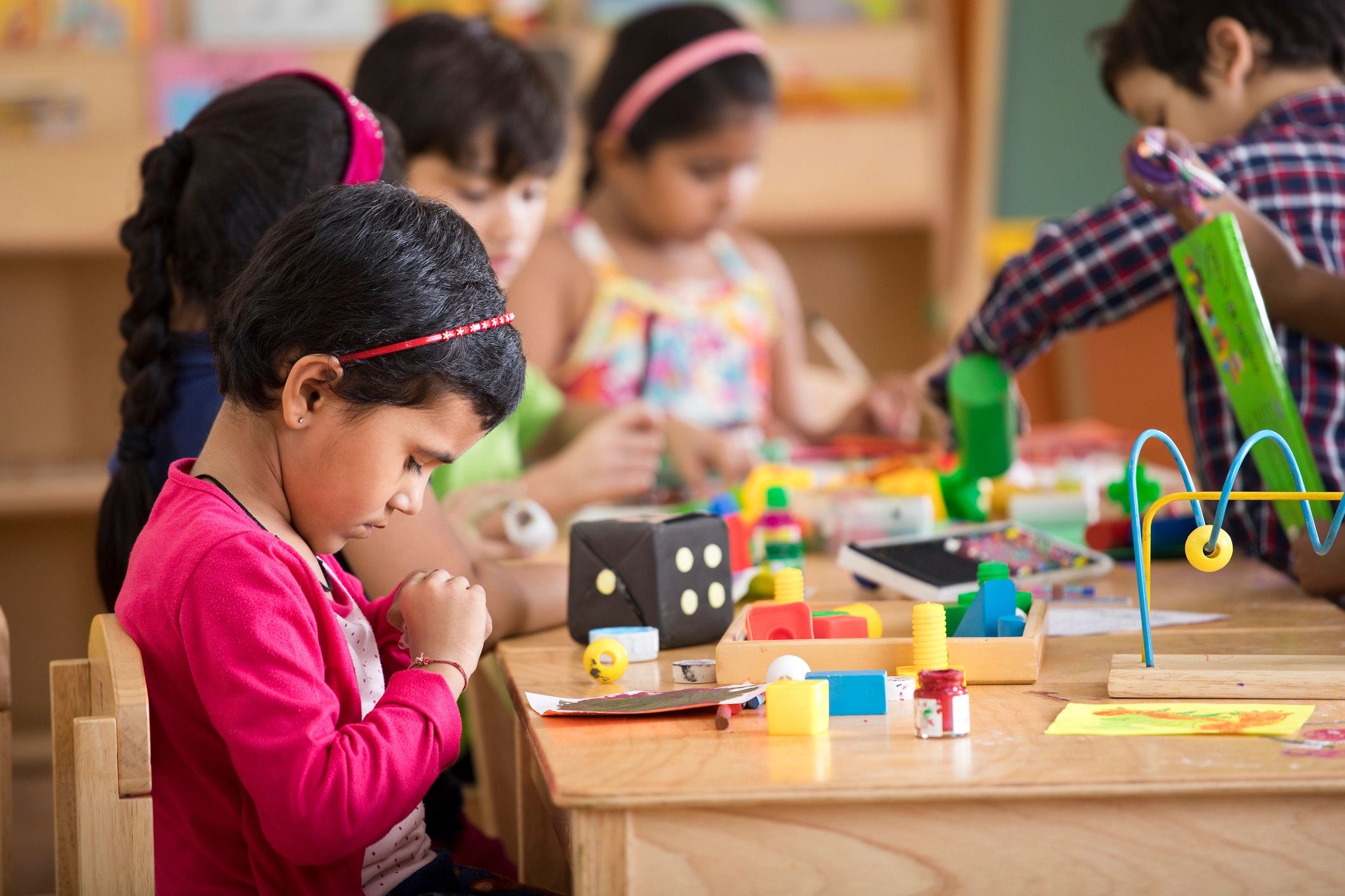 Preschool children drawing and painting at a table