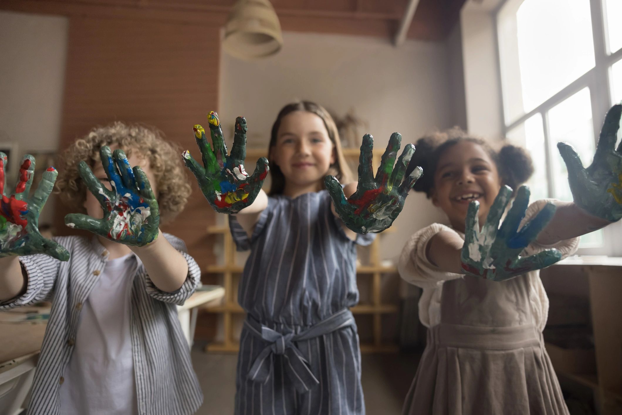 Children showing colorful painted hands, representing creativity and community