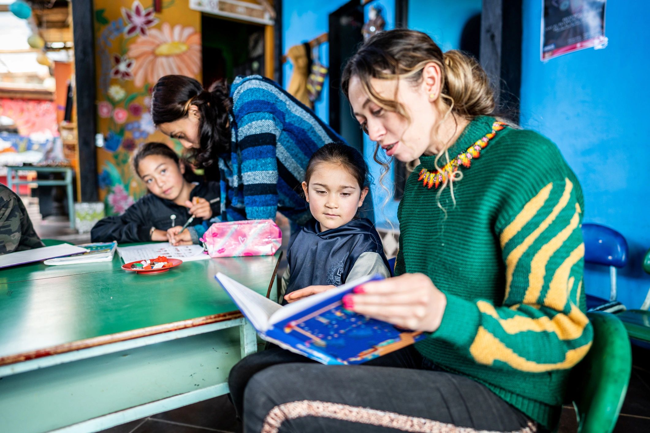Teacher reading a book with children in a bright classroom
