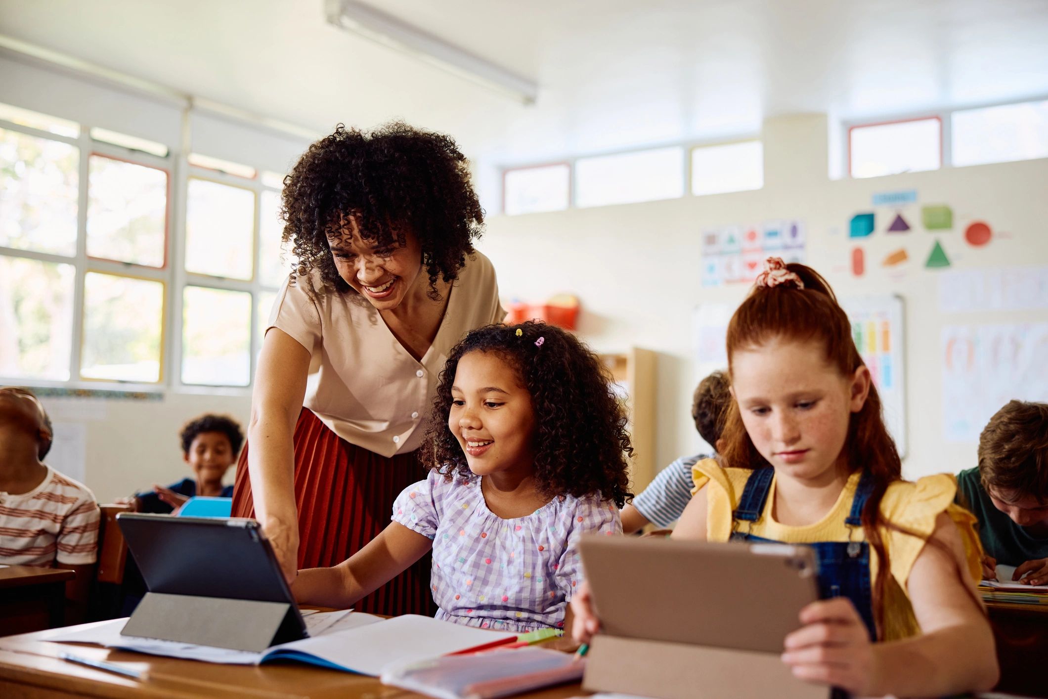 Teacher helping a student using a tablet in class
