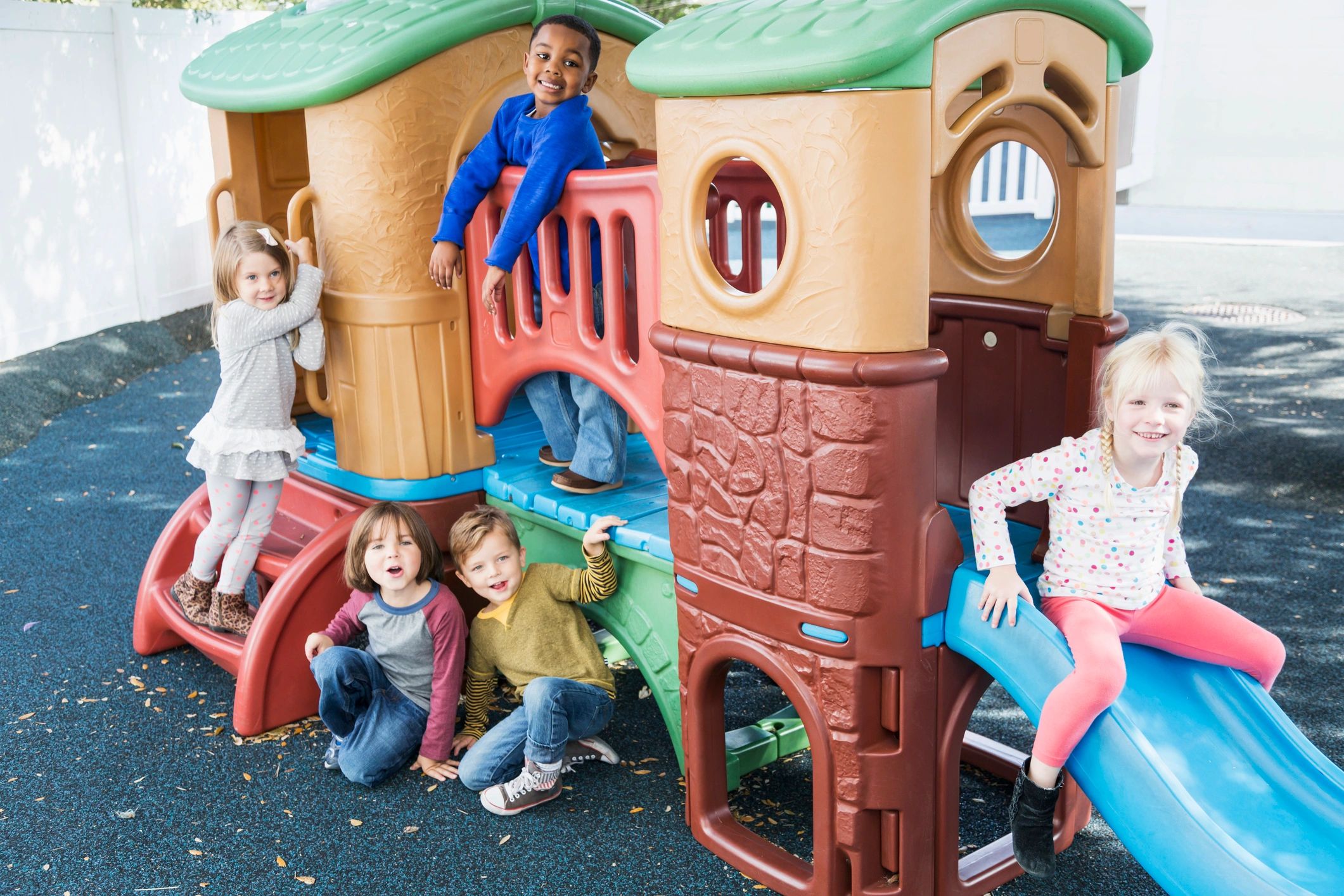 Preschoolers smiling on playground equipment